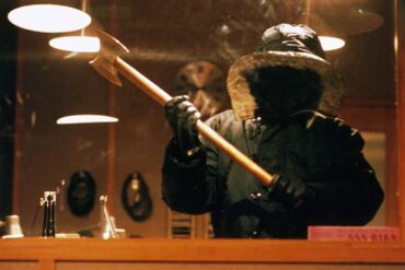 Urban Legend (1998) - The Killer Stalks in The Univerisity Radio Statio,, wearing a snow jacket that obscures their identity, wielding an axe