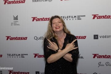 Izzy Lee at the Fantasia Film Festival Red Carpet giving the devil horns with both hands
